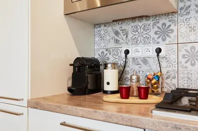 a kitchen counter with a coffee maker and cups on it at Luxury riverside apartment in Prague