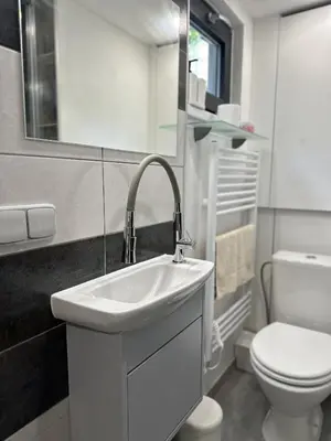 a white bathroom with a sink and a toilet at Mini Apartman - G - Vyhlídka nad řekou in Zámky