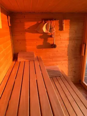 a sauna with two wooden benches in a room at Mini Apartman - G - Vyhlídka nad řekou in Zámky