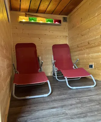 two red chairs sitting inside of a sauna at Mini Apartman - G - Vyhlídka nad řekou in Zámky