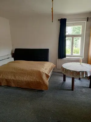 a bedroom with a bed and a table and a window at Chalupa pod hradem Talmberk in Samopše