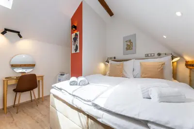 a bedroom with a large white bed and a desk at Classy Loft Apartment in the City Center of Prague in Prague