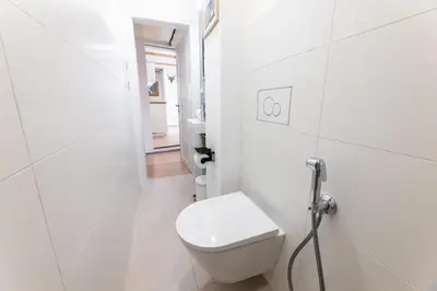 a white bathroom with a toilet and a hallway at Classy Loft Apartment in the City Center of Prague in Prague
