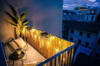 a balcony with a chair and a table and lights at 3BR & 2,5Bath Heaven of Harmony 2 Theater VIEW in Prague