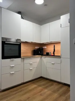 a kitchen with white cabinets and a microwave at Apartment A l Modern Stay with Parking in Prague