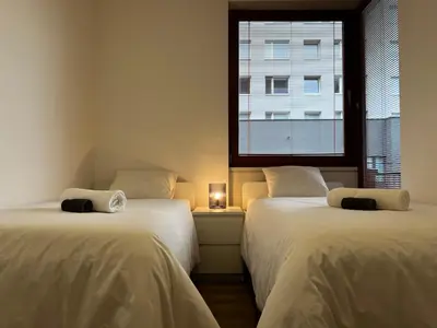 two beds in a room with a window at Apartment A l Modern Stay with Parking in Prague