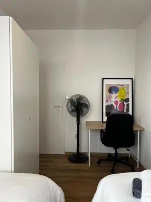 a bedroom with a desk and a chair and a fan at Apartment A l Modern Stay with Parking in Prague