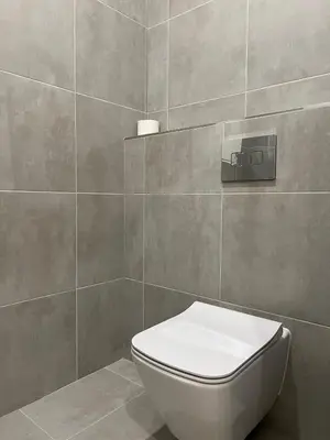 a bathroom with a toilet and a tile wall at Apartment A l Modern Stay with Parking in Prague