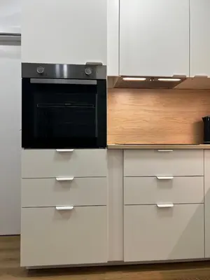 a kitchen with white cabinets and a black microwave at Apartment A l Modern Stay with Parking in Prague