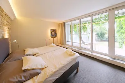 a room with a table and a bed and a bedroom at ViDa Prostorný 220 m2 3BR Apartmán s Krbem a Zahradou, Ideální pro Rodiny in Prague