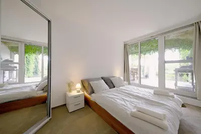 a bedroom with a large white bed with a window at ViDa Prostorný 220 m2 3BR Apartmán s Krbem a Zahradou, Ideální pro Rodiny in Prague