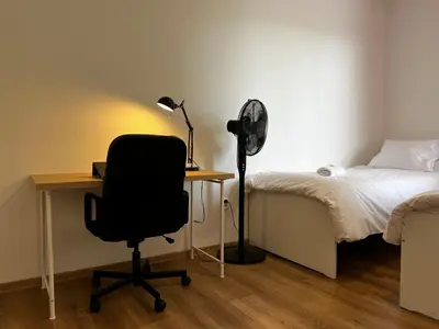 a bedroom with a desk and a chair next to a bed at Apartment B l Modern Stay with Parking in Prague
