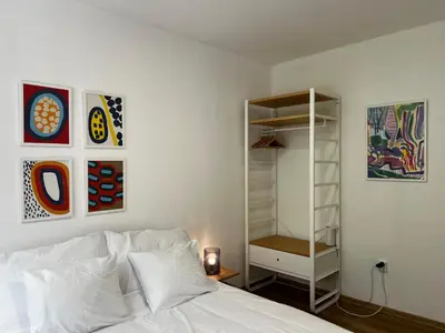 a bedroom with a bed and some paintings on the wall at Apartment B l Modern Stay with Parking in Prague