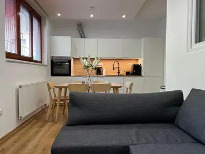 a kitchen and dining room with a couch and a table at Apartment B l Modern Stay with Parking in Prague