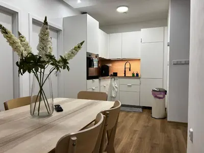 a dining room table with a vase of flowers on it at Two Modern Apartments with Complimentary Parking in Prague