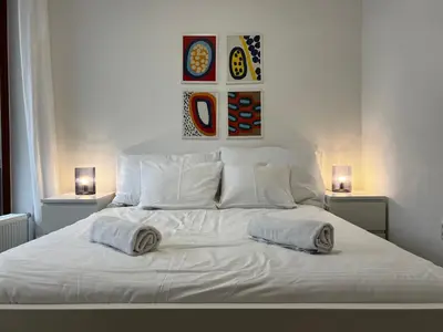 a white bed with two pillows on top of it at Two Modern Apartments with Complimentary Parking in Prague