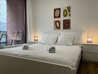 a white bed with towels on it in a bedroom at Two Modern Apartments with Complimentary Parking in Prague