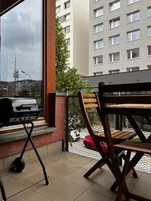 a chair sitting on a balcony next to a window at Two Modern Apartments with Complimentary Parking in Prague