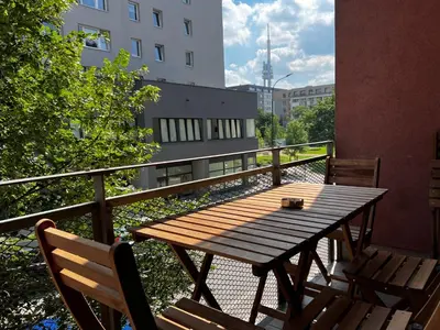 a wooden table and chairs on a balcony at Two Modern Apartments with Complimentary Parking in Prague