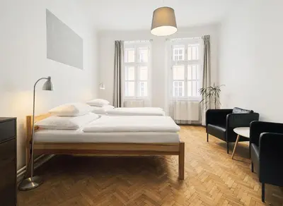 a bedroom with two beds and a table and chairs at Teytz Apartments in Prague