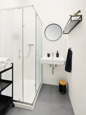 a bathroom with a glass shower and a sink at Teytz Apartments in Prague