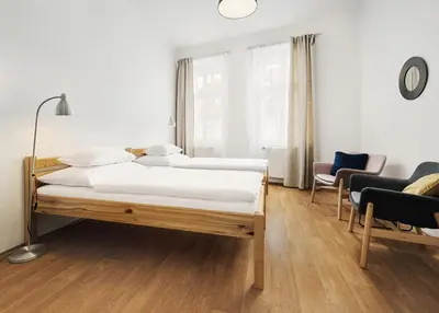 a bedroom with two beds and chairs in it at Teytz Apartments in Prague