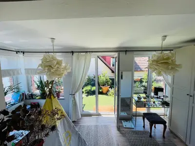 a living room with sliding glass doors and a room with flowers at Flat with heart and art nearby centre of the Prague in Prague