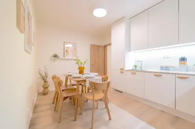 a kitchen and dining room with a table and chairs at Bright 2BR - 5th floor, Balcony, Free Parking by Gravity Prague in Prague