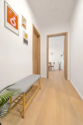 a hallway with a bench in a white room at Bright 2BR - 5th floor, Balcony, Free Parking by Gravity Prague in Prague