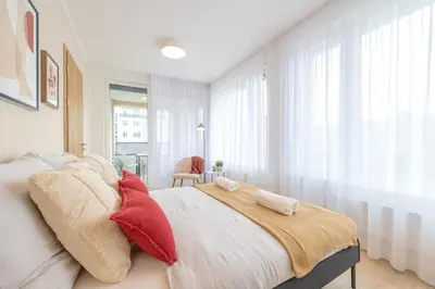 a bedroom with a large bed with red pillows at Bright 2BR - 5th floor, Balcony, Free Parking by Gravity Prague in Prague