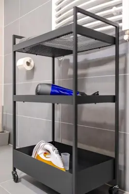 a black shelf with a blow dryer on it at Bright 2BR - 4th floor, Balcony, Free Parking by Gravity Prague in Prague