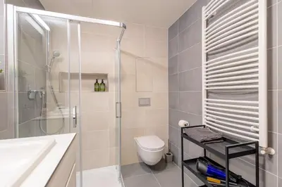 a bathroom with a shower and a toilet and a sink at Bright 2BR - 4th floor, Balcony, Free Parking by Gravity Prague in Prague