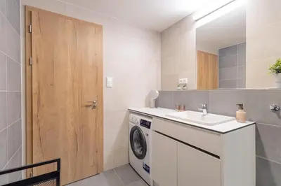 a bathroom with a washing machine and a sink at Bright 2BR - 4th floor, Balcony, Free Parking by Gravity Prague in Prague
