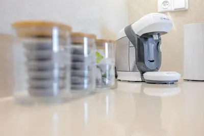 a coffee maker and cups on a counter at Bright 2BR - 4th floor, Balcony, Free Parking by Gravity Prague in Prague