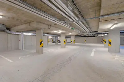 an empty parking lot in a building with yellow arrows at Bright 2BR - 4th floor, Balcony, Free Parking by Gravity Prague in Prague