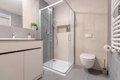 a bathroom with a shower and a toilet and a sink at Bright 2BR - 4th floor, Balcony, Free Parking by Gravity Prague in Prague