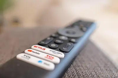 a remote control sitting on top of a couch at Bright 2BR - 4th floor, Balcony, Free Parking by Gravity Prague in Prague