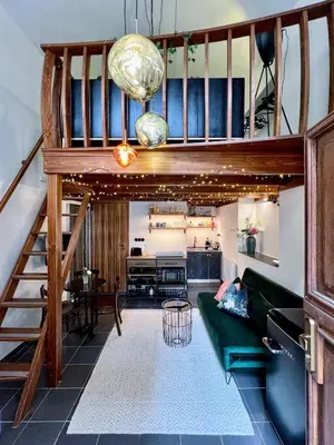 a living room with a green couch and stairs at WOW MiniLoft, near Wenceslas Square, city centre, fast wifi in Prague