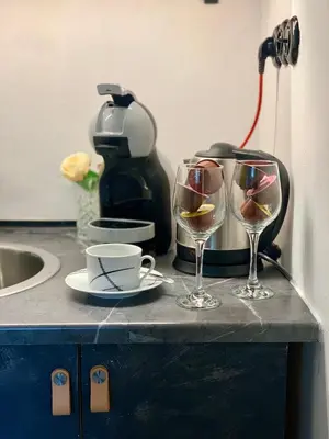 two glasses of wine on a counter with a coffee maker at WOW MiniLoft, near Wenceslas Square, city centre, fast wifi in Prague