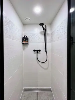 a shower stall in a bathroom with white tiles at WOW MiniLoft, near Wenceslas Square, city centre, fast wifi in Prague