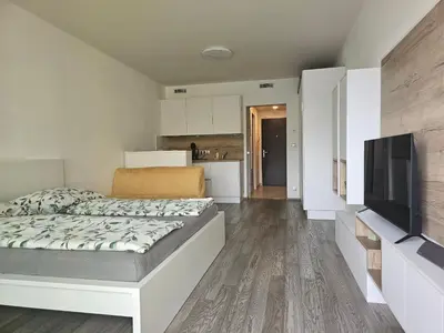 a bedroom with a bed and a flat screen tv at NEW Apartment - O2 Arena Prague with parking in Prague