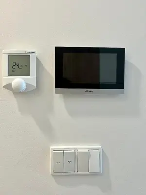 a tv on a wall with a clock and a clock at Cozy studio prague 5 in Prague