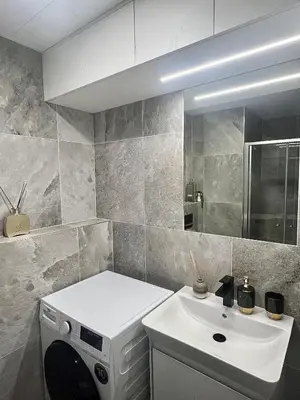 a bathroom with a sink and a washing machine at Cozy studio prague 5 in Prague
