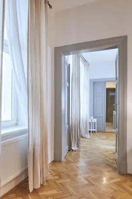 an empty room with white curtains and wooden floors at Wenceslas Square Residence in Prague