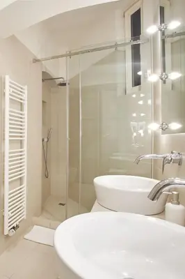 a white bathroom with a sink and a shower at Wenceslas Square Residence in Prague