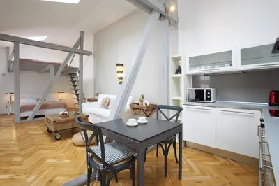 a kitchen and living room with a table and chairs at Wenceslas Square Residence in Prague