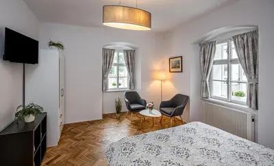 a bedroom with a bed and two chairs in it at Penzion Popelka in Roudnice nad Labem