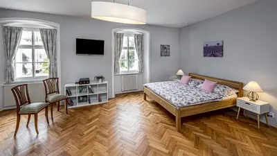 a bedroom with a bed and a table and chairs at Penzion Popelka in Roudnice nad Labem