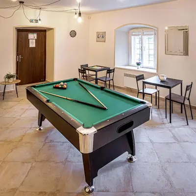 a pool table in a room with tables and chairs at Penzion Popelka in Roudnice nad Labem