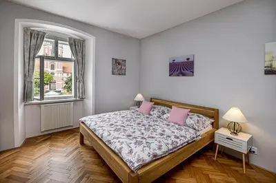 a bedroom with a bed with pink pillows and a window at Penzion Popelka in Roudnice nad Labem